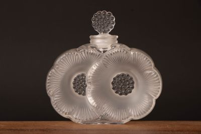 une bouteille en verre transparent ornée d'un motif floral