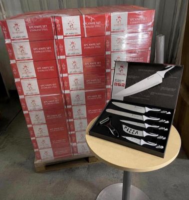 a box of knives on a table next to a stack of boxes