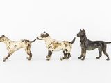 three figurines of dogs on a white background