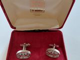 pair of cufflinks in a red velvet box with red velvet lining