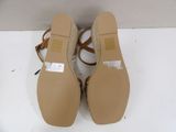 the woman ' s shoes are on a white surface with a white background