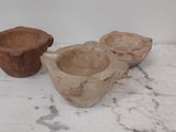 trois bols en bois posés sur une table en marbre