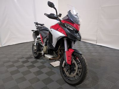 a red and white motorcycle parked on a black and white checkered floor