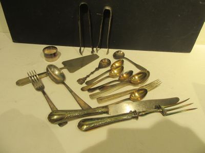 de nombreux couverts sur une table, avec une boîte noire en arrière-plan