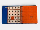 an orange binder that has a bunch of coins in it