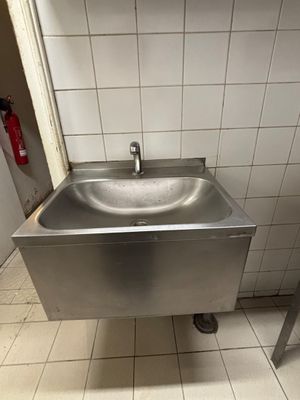 a sink in the corner of a public restroom
