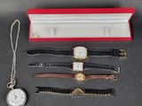 trois montres et une montre dans un coffret rouge posé sur une table