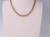 a gold chain necklace on a mannequin mannequin