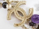chanel necklace with pearls and amethorate beads on a white surface