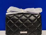 black quilted purse with a white bow on top of it