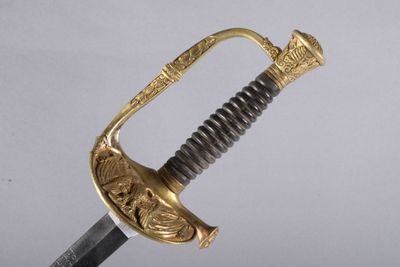 une vieille épée avec un manche en or sur fond blanc