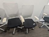 quatre chaises de bureau alignées dans une pièce vide
