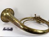 un instrument à vent en laiton exposé sur une surface blanche