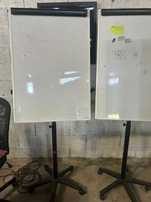 deux tableaux blancs posés sur un support à côté d'une chaise