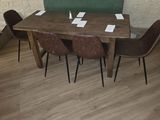 une table avec quatre chaises et un banc dans une pièce