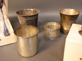 silver cups and spoons sitting on a table next to a box