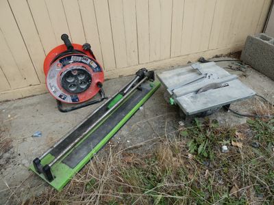 two tools that are laying on the ground next to a building