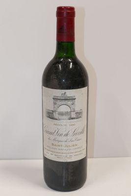 une bouteille de vin rouge posée sur une table blanche