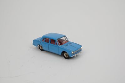 une petite voiture miniature posée sur une surface blanche