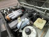 un moteur de voiture dont le capot est ouvert, garé dans la rue