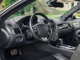 the interior of a car with the door open and the driver ' s seat down