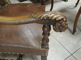 a brown leather chair with a lion head on it