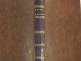 an old book with a brown cover sitting on top of a white table