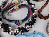 many necklaces and bracelets laid out on a table