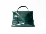a green leather handbag on a white background