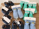 de nombreuses paires de chaussures et de chaussettes pour bébé posées sur une table