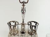 an image of a silver plate with three cups and a vase on it