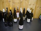 bottles of wine are lined up on a table in front of a wooden wall