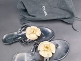 une paire de sandales Chanel et un sac posés sur une table