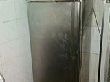 a stainless steel refrigerator in the corner of a kitchen