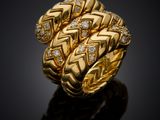 a gold ring with diamonds on a black surface
