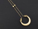 un collier en or orné d'un croissant et de perles sur fond noir