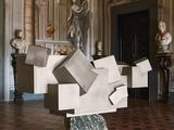 a sculpture in the middle of a room with statues in the background