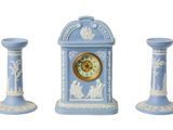 trois vases bleus et blancs et une horloge sur fond blanc