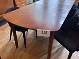 a table and chairs in a room with a large window