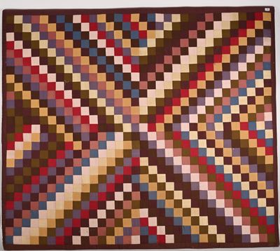 une couette marron, rouge et bleue, avec des carrés dessus