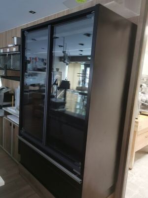 a refrigerator in the middle of a kitchen with a microwave on top of it