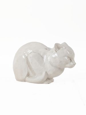 a white cat figurine sitting on a white surface
