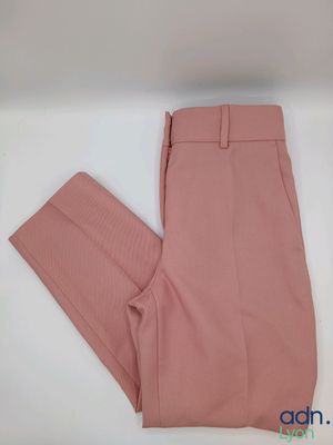un gros plan sur un pantalon rose posé sur une surface blanche