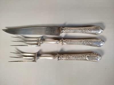 quatre fourchettes et un couteau sur une table blanche