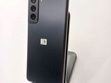 the back of a black cell phone sitting on top of a white surface