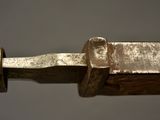 a close up of a knife on a piece of wood