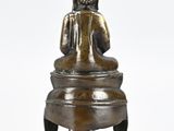 statue of a buddha sitting on a stool on a white background