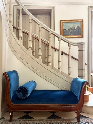 un canapé bleu placé devant un escalier