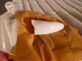 a person holding a piece of food that is covered in caramel