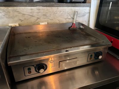un plan de travail en acier inoxydable équipé d'une plaque de cuisson